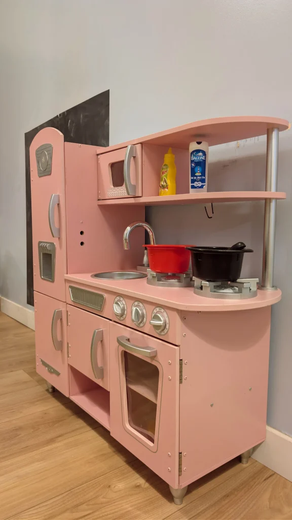 Coin cuisine pédagogique en bois à la MAM Les Chérubins à Perpignan, équipé d'ustensiles de jeu.