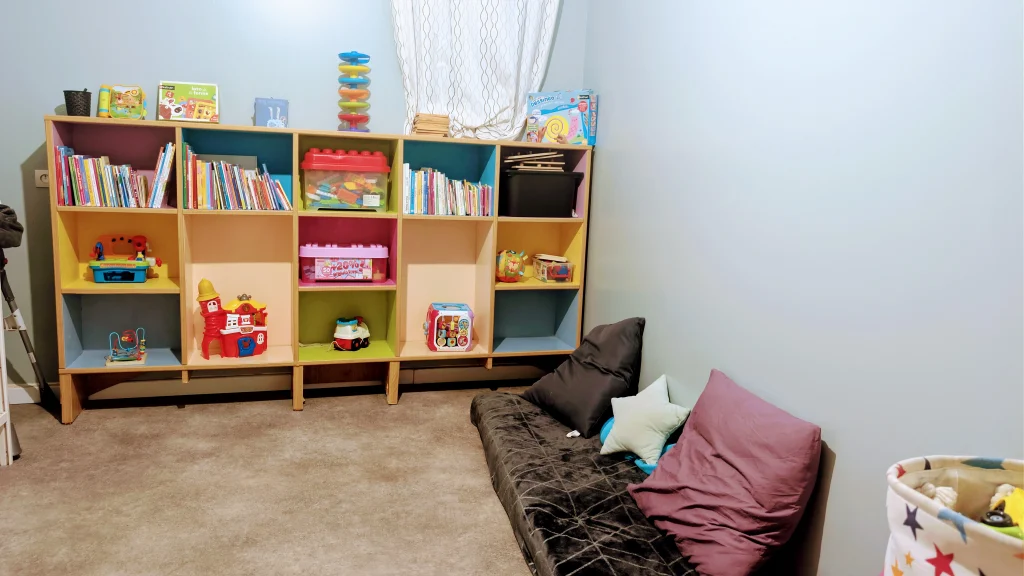 Coin lecture douillet avec coussins et étagères de jeux éducatifs à la Maison d'Assistantes Maternelles Les Chérubins à Perpignan