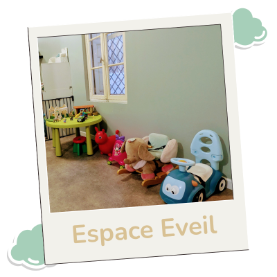 Photo Polaroid de l'espace éveil avec une table d'activités verte, un éléphant à bascule et des jouets de motricité.
